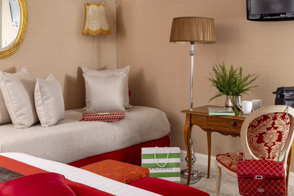 Visit Paris with kids : room for 3 persons, single bed, with shopping bags, desk and armchair at the hotel de seine